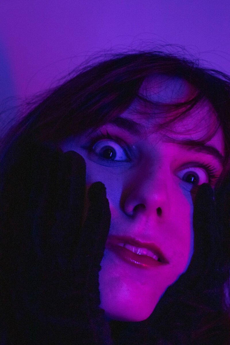 red portrait of a woman looking directly into camera crazily