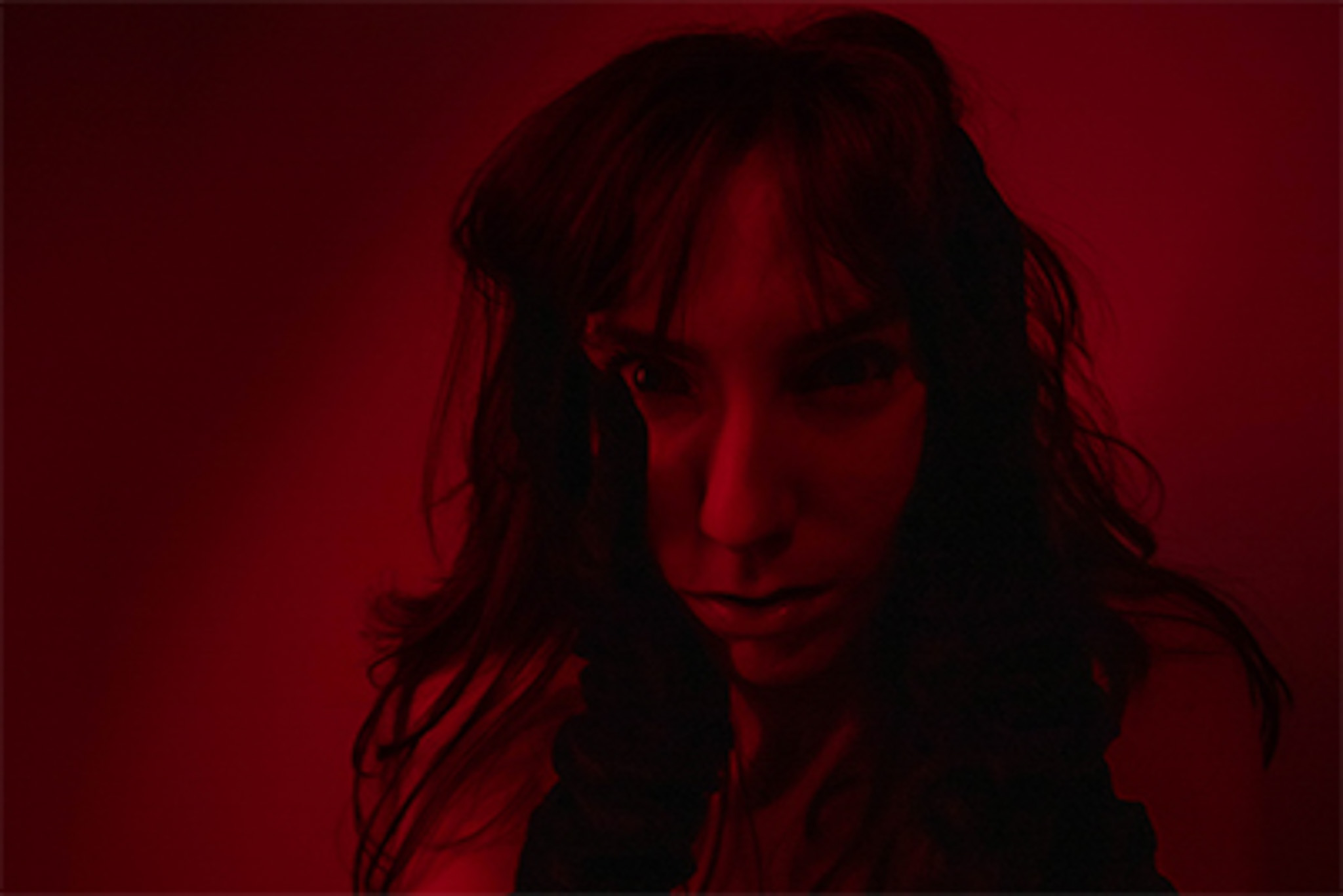 red portrait of a woman looking directly into the lens with crazy eyes