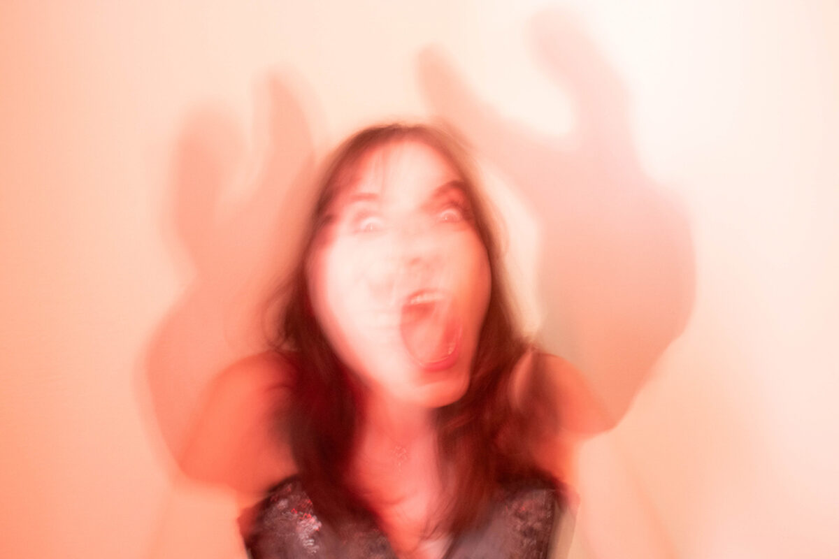 red portrait of a woman looking directly into camera crazily